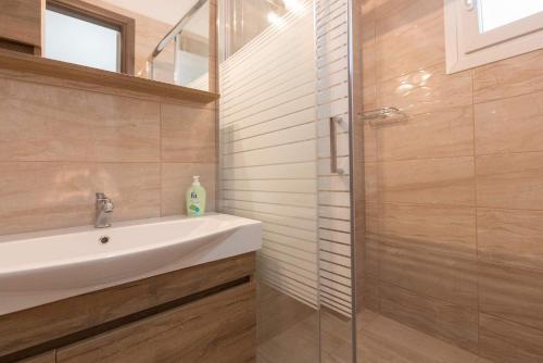 a bathroom with a sink and a glass shower at Villa Venetta in Skala Rachoniou