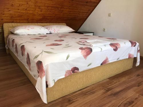 a bedroom with a bed with pink flowers on it at Stone House Center in Primošten