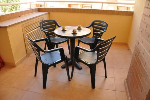 una mesa y 4 sillas sentadas en un balcón en ACV - Costa Caribe I - 2ª linea, planta 2, norte - 2, en Oropesa del Mar