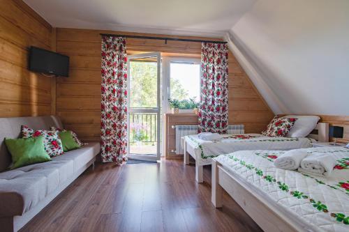 ein Wohnzimmer mit zwei Betten und einem Fenster in der Unterkunft Gliczarówka in Gliczarów Górny