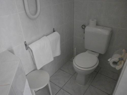 a white bathroom with a toilet and a sink at Hotel Le Golfe Bleu in Cavalaire-sur-Mer