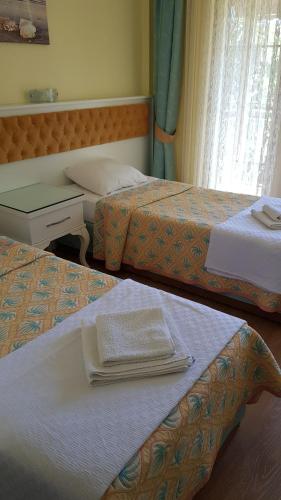 a hotel room with two beds with towels on them at İlkiz Beach Hotel in Oludeniz
