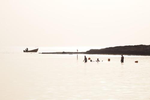 a group of people playing in the water on a beach at Dor village in Dor