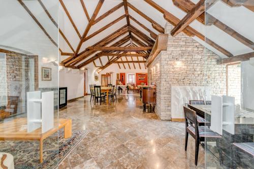 an open living room with wooden ceilings and a brick wall at DVORAC “KAŠTIL JELA” in Milna