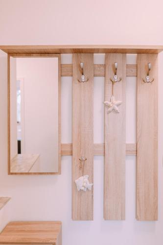 a mirror on a wall next to a wooden shelf at Villa Sarah in Klimno
