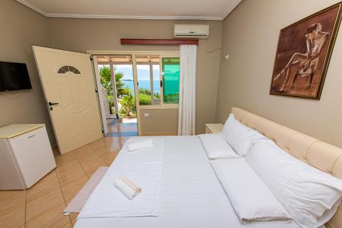 ヴロラにあるHotel Roiのベッドルーム1室(大きな白いベッド1台、ドア付)