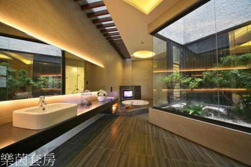 a bathroom with a tub and a sink and an aquarium at Doule Motel in Taichung
