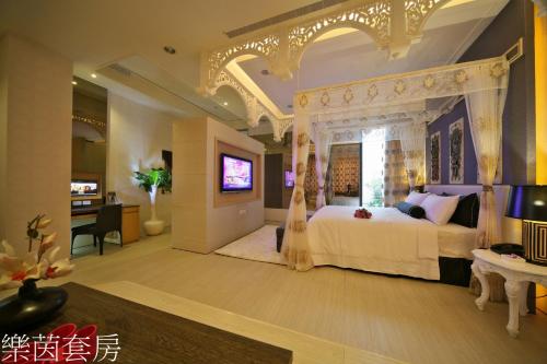 a bedroom with a white bed with a canopy at Doule Motel in Taichung