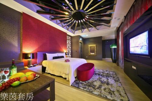 a hotel room with a bed and a television at Doule Motel in Taichung