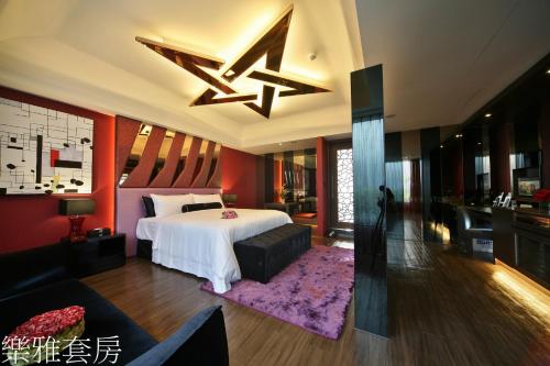 a bedroom with a bed and a living room at Doule Motel in Taichung