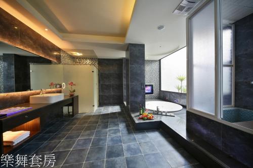 a bathroom with a tub and a sink and a bath tub at Doule Motel in Taichung