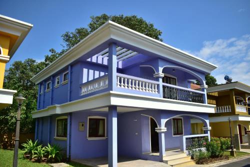 a blue house with a balcony at Calvin's 3 BDR Villa in Benaulim