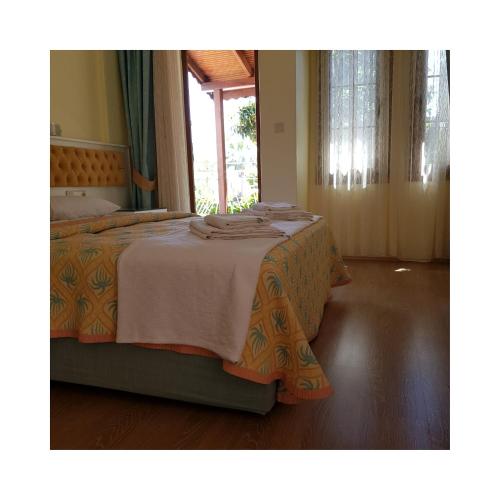 a bedroom with a bed with a white and orange blanket at İlkiz Beach Hotel in Oludeniz