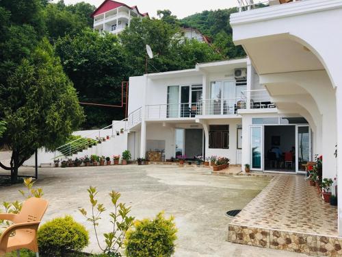 uma grande casa branca com um grande pátio em Rezo's House em Kvariati