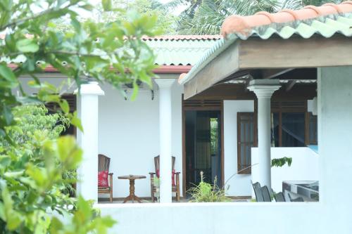 a white house with a table and chairs at Villa Koggala in Koggala