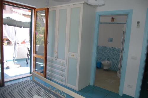 uma casa de banho com um WC e uma porta de vidro em La Rosada em Giglio Porto