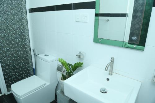 a bathroom with a white sink and a mirror at Villa Koggala in Koggala