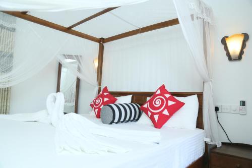 a bedroom with a bed with red and white pillows at Villa Koggala in Koggala