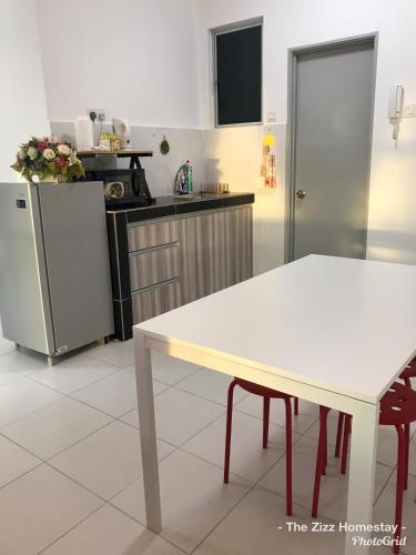 a kitchen with a white table and a refrigerator at The Zizz Homestay@Damansara Damai in Petaling Jaya