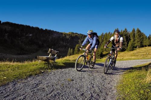 two people riding bikes on a dirt road at Sorell Hotel Tamina - Garni in Bad Ragaz