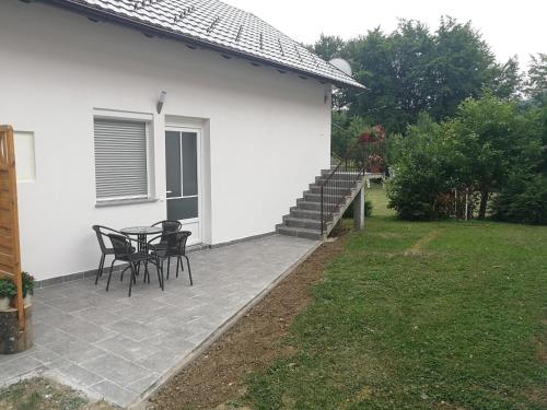 a patio with two chairs and a table next to a house at New apartment near Plitvice lakes in Smoljanac