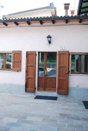 a white building with wooden doors and windows at Casa rosa sull'appennino tosco emiliano in Barigazzo