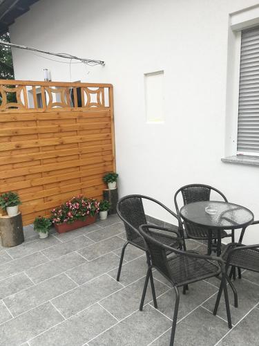 a patio with a table and chairs and a fence at New apartment near Plitvice lakes in Smoljanac