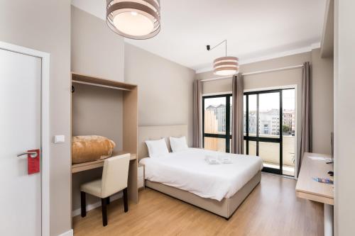 una camera con letto, scrivania e sedia di Oporto Bonjardim Residence a Porto