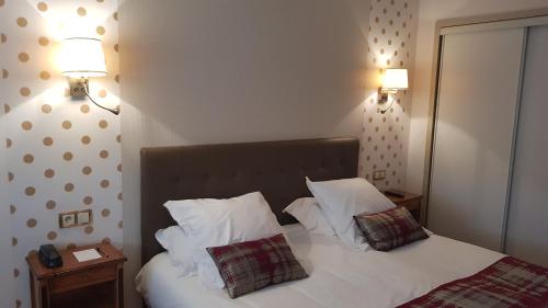 a bedroom with a bed with white sheets and pillows at Hotel de Champagne in Épernay