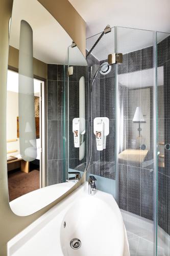 une salle de bain avec un lavabo et une douche avec un miroir dans l'établissement ibis Marne La Vallee Champs-sur-Marne, à Champs-sur-Marne