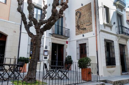 a tree in front of a white building at Sa Voga Hotel & Spa in Arenys de Mar