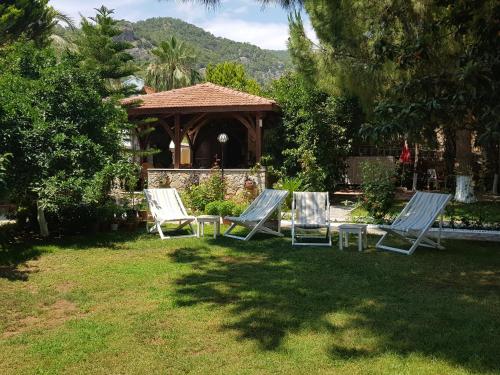 two lounge chairs and a gazebo in a yard at İlkiz Beach Hotel in Oludeniz