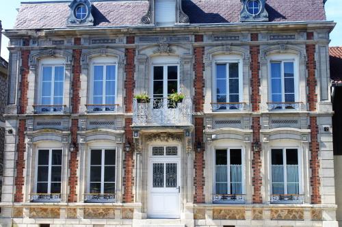 a brick building with white doors and windows at LE JABLOIRE in Florent-en-Argonne