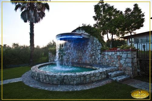 a fountain in a yard with a stone wall at Villa La Rena in Anagni