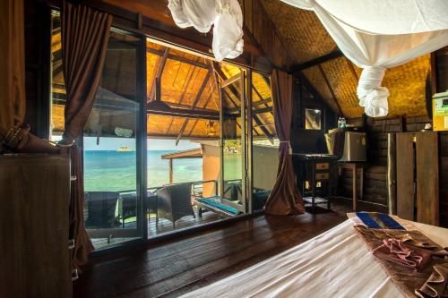 a room with a bed with a view of the ocean at Taatoh Seaview Resort - SHA Plus in Koh Tao