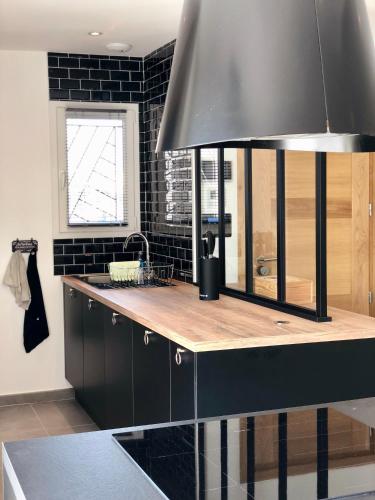 - une cuisine avec un évier et un mur noir dans l'établissement Les Villas Black&White, à Palau-del-Vidre