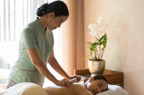 a woman is giving a woman a massage at The Sukhothai Bangkok - SHA Plus Certified in Bangkok