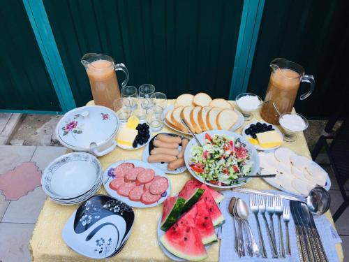 una mesa cubierta con platos de comida y fruta en Hotel Garden, en Tiflis