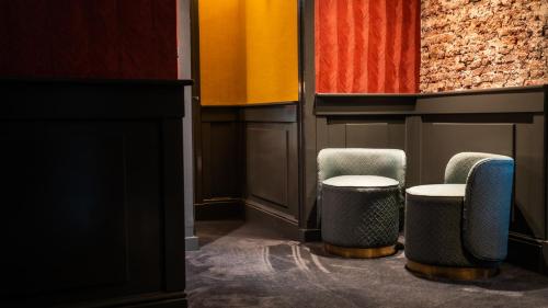 a room with two chairs and a table at Hotel Frank since 1666 in Amsterdam