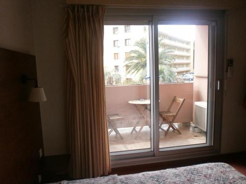 a bedroom with a sliding glass door to a balcony at Hôtel Maya in Cavalaire-sur-Mer