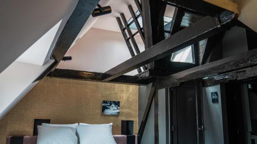 a bed with white pillows in a room at Hotel Frank since 1666 in Amsterdam