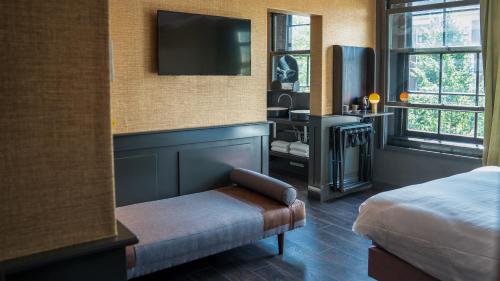 a hotel room with a bed and a tv at Hotel Frank since 1666 in Amsterdam