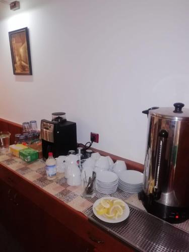 a counter with cups and plates and a coffee maker at Penzion U Papoušků in Jindrichuv Hradec