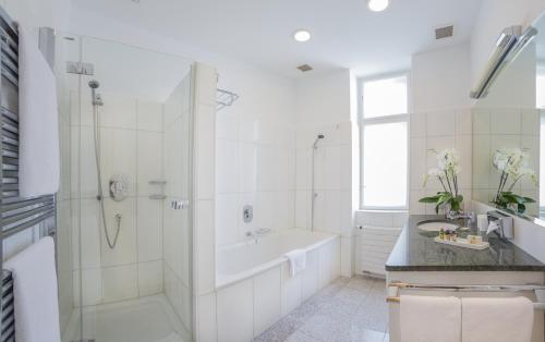 a white bathroom with a tub and a shower at Appartement-Hotel an der Riemergasse in Vienna