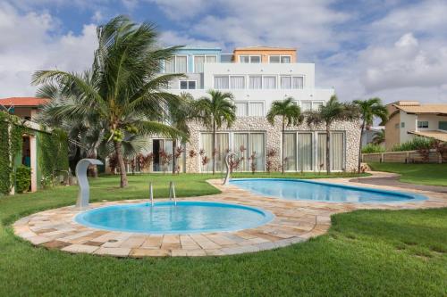 a villa with a swimming pool and a building at As Coloridas in Praia dos Carneiros