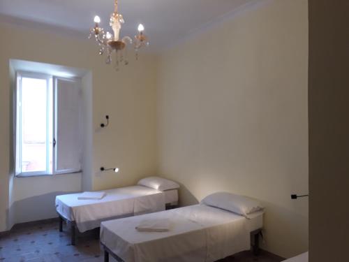 um quarto de hospital com duas camas e um lustre em AFFITTACAMERE ROMANSTYLE em Roma