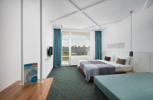 a hotel room with two beds and a window at Sunrise Blue Magic Resort - All Inclusive in Obzor