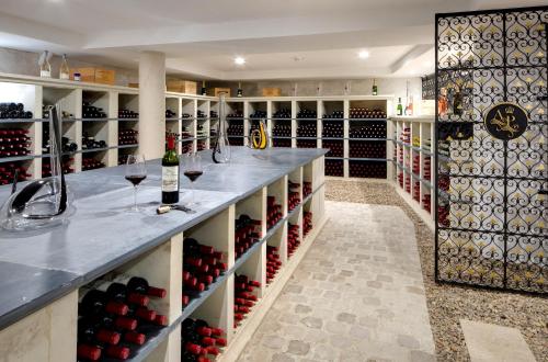 a wine tasting room with wine bottles on shelves at Alexandra Palace - La Maison Younan in Mazières-en-Gâtine