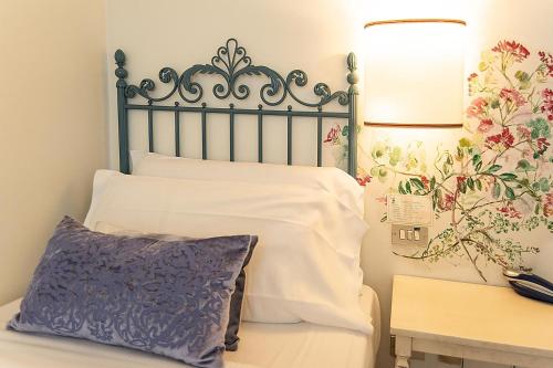 a bed with a blue headboard and a pillow at Albergo Al Moretto in Castelfranco Veneto