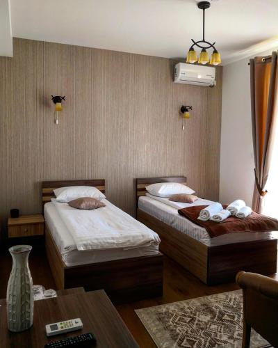 a hotel room with two beds and a table at Pensiunea Casa Hortopan in Târgu Jiu
